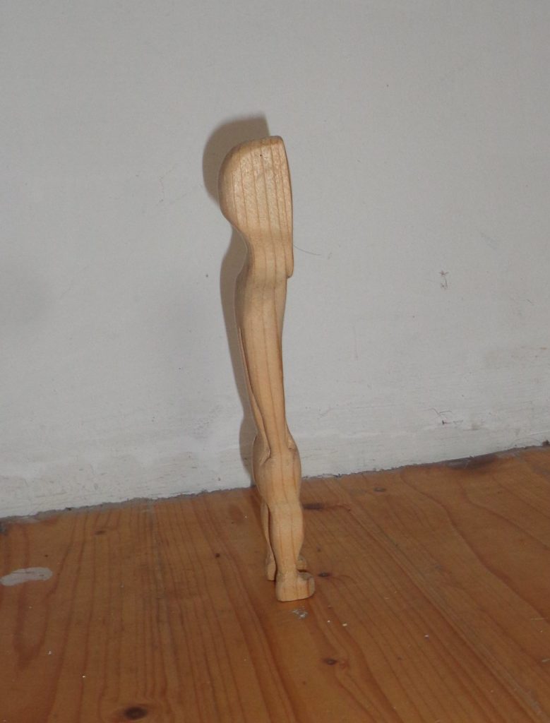 Kapo seitlich. Holzfigur aus Händen in der Tasche